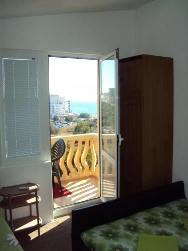a bedroom with a balcony with a view of the ocean at Planet in Dobra Voda