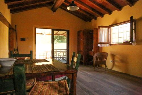 a living room with a wooden table and chairs at Casale Vigna Carbona in Gavorrano