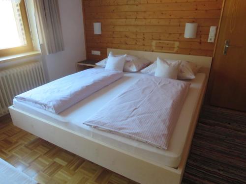 ショペルナウにあるHaus Manserのベッドルーム1室(大型ベッド1台、白いシーツ、枕付)