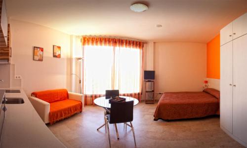 a small room with a bed and a table and a room at Llave de Granada in Alcalá la Real