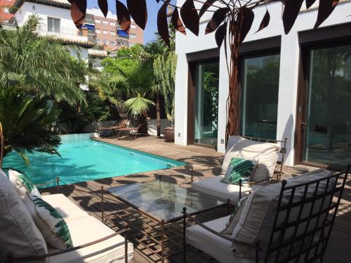 a patio with chairs and a swimming pool at la casa de las pergolas in Seville