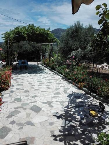 a stone walkway with a table and chairs and flowers at Toulatos Pantelis in Pouláta