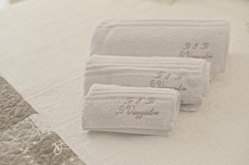 due asciugamani bianchi posti sopra un letto di Il Viaggiatore B&B a Lecce
