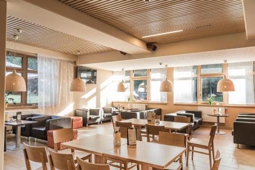 a restaurant with tables and chairs and windows at JUFA Hotel Grünau im Almtal in Grünau im Almtal