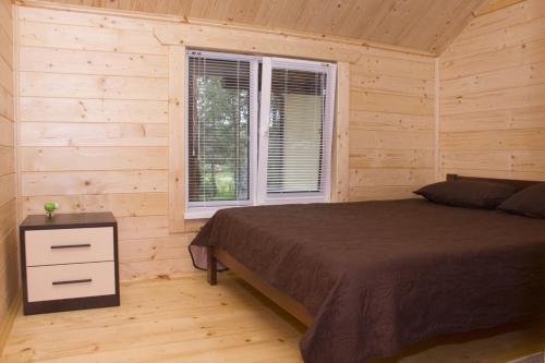una camera da letto con un letto e una finestra di Cottage in Sosnovom Boru a Kobleve