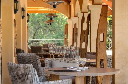 a restaurant with tables and chairs with wine glasses at La Villa Vicha, The Originals Relais in Aubais