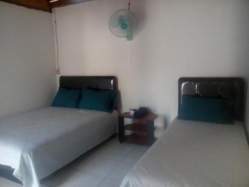 two beds in a room with blue pillows at Izaac's Bed & Breakfast in Lovina