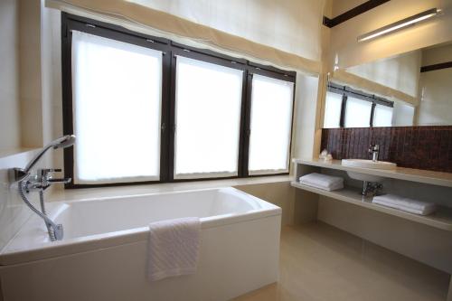 La salle de bains est pourvue d'une baignoire et d'une fenêtre. dans l'établissement Hotel Vabank, à Golub-Dobrzyń