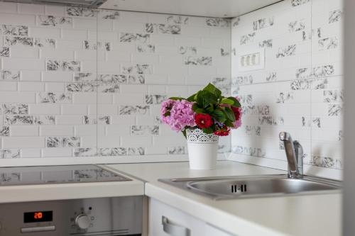a kitchen with a sink and a vase of flowers at Apartments Sunset in Ražanj