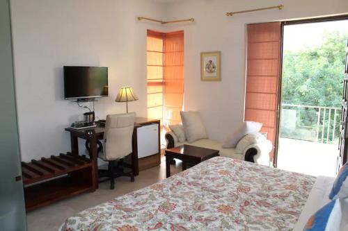 a bedroom with a bed and a desk and a television at Perch Arbor Suites in Gurgaon