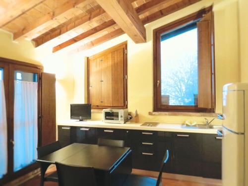 una cucina con tavolo, lavandino e finestra di Agriturismo Cascina Nuova a Cremona