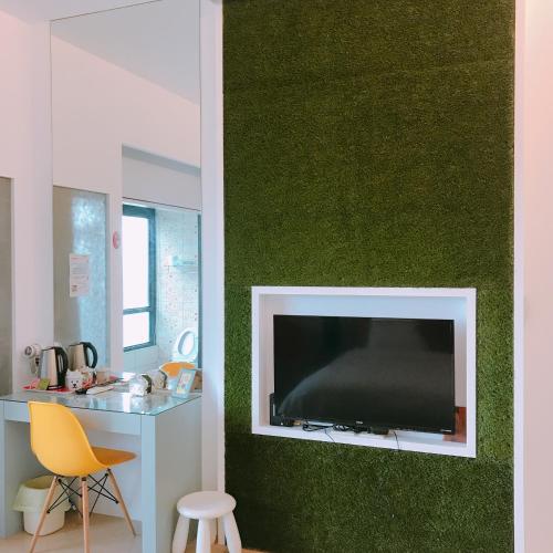 a living room with a flat screen tv on a green wall at 旅人空間The Cube Inn Homestay本民宿未與Agod a合作 We are not partnered with Agod a in Dongshan