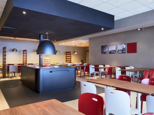 a dining room with tables and chairs and a cafeteria at Campanile Paris Est - Pantin in Pantin