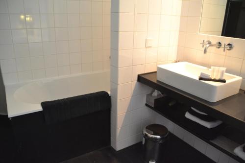 a bathroom with a sink and a bath tub at Château Les Merles et ses Villas in Mouleydier