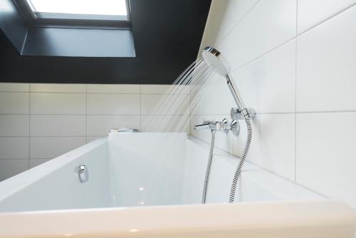 a shower in a bathroom with a tub at Thon Hotel Spectrum in Oslo