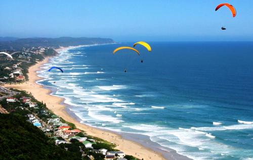 a group of kites flying over a beach at Serendipity Country House & Restaurant in Wilderness