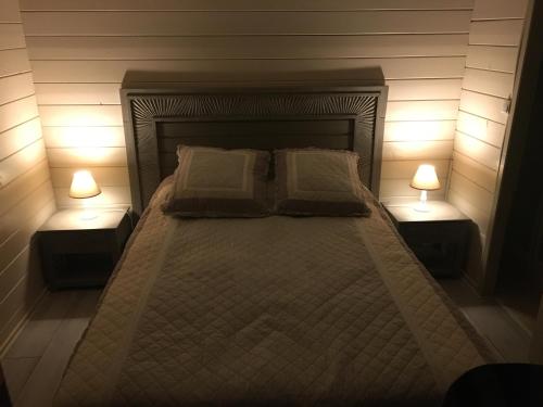 a bedroom with a bed with two lamps on it at chalet golfe de st tropez in Grimaud
