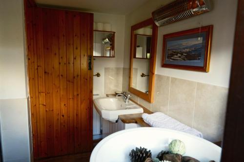 ein Badezimmer mit einem Waschbecken und einer Badewanne in der Unterkunft Barn Cottage in Brecon