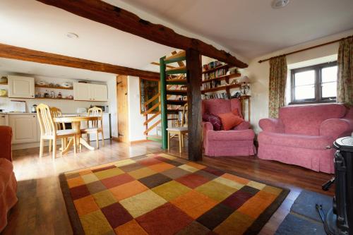 a living room with two chairs and a table at Barn Cottage in Brecon