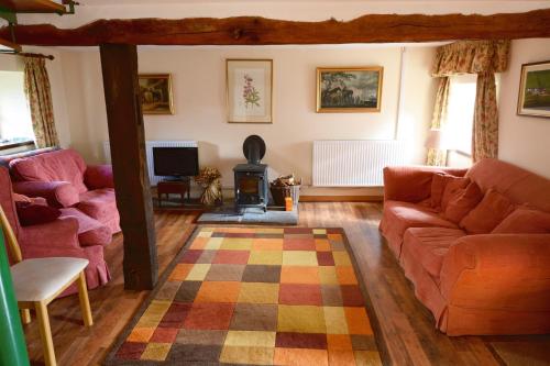 a living room with two couches and a fireplace at Barn Cottage in Brecon