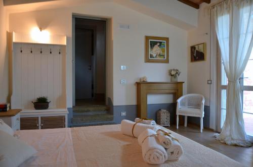 een slaapkamer met een bed en handdoeken op de vloer bij Elisabeth House in Lucignano