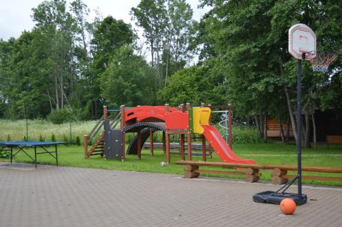 a park with a playground with a slide at Guest House Kalnu pūpoli in Šengeida