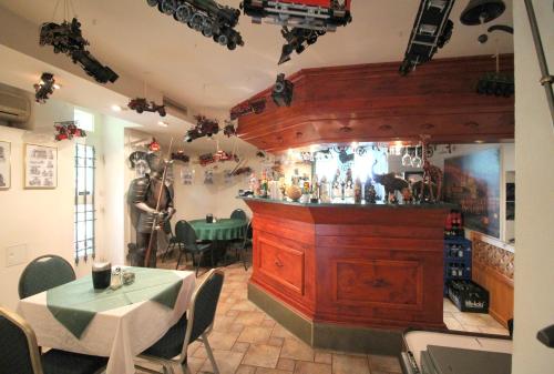 a bar in a restaurant with a man standing behind it at Hotel Zu den Linden in Dresden