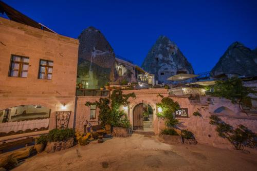 an old building with mountains in the background at Koza Cave Hotel in Göreme