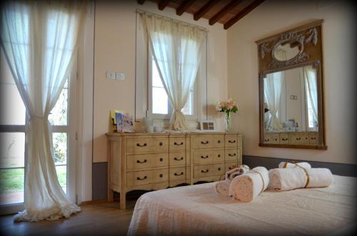 a bedroom with a bed with a dresser and a mirror at Elisabeth House in Lucignano