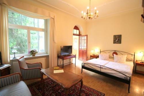 a bedroom with a bed and a living room at Hotel-Appartement-Villa Ulenburg in Dresden