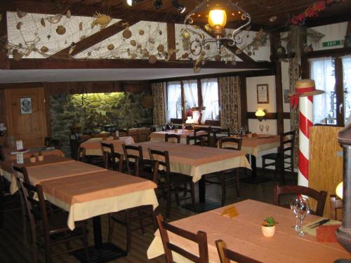 ein Restaurant mit Tischen und Stühlen in einem Zimmer in der Unterkunft Hotel Pension Spycher in Kandersteg