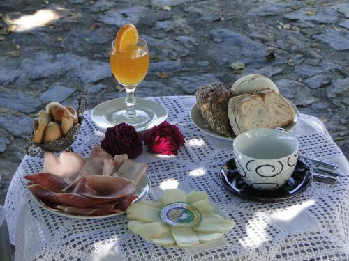 una mesa con un plato de comida y un vaso de zumo de naranja en Vila Maria, en Castelo de Vide