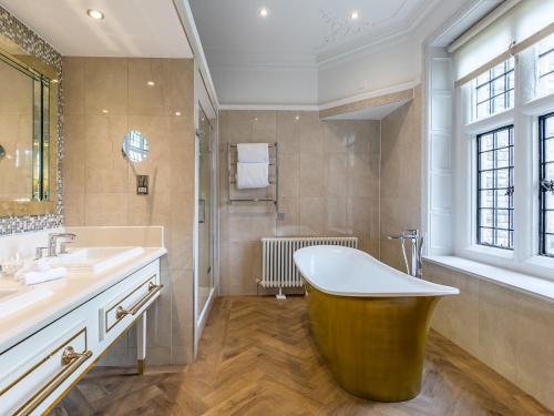 a bathroom with a tub, sink, and toilet at Rhinefield House Hotel in Brockenhurst