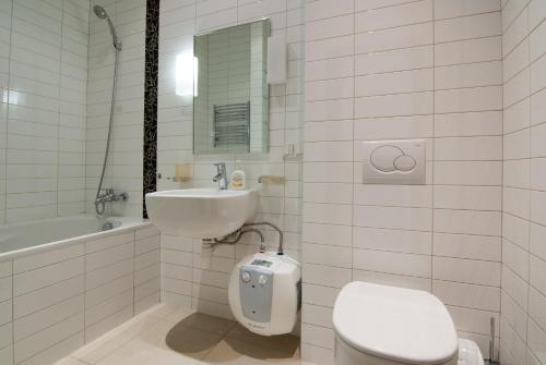 a white bathroom with a toilet and a sink at Home Hotel Apartments on Zoloti Vorota in Kyiv