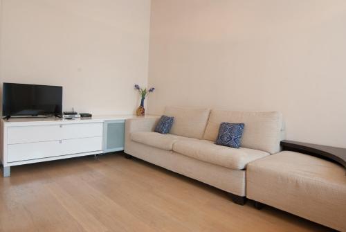 a living room with a couch and a tv at Home Hotel Apartments on Zoloti Vorota in Kyiv