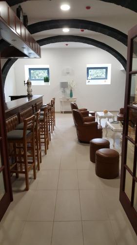a room with chairs and tables and a bar at Solar Do Conde Garden Hotel in Capelas