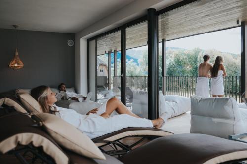 a woman sitting on a couch in a living room at B&B Boutique Apartment Oberwiesen in Brunico