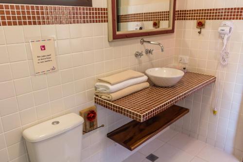 a bathroom with a sink and a toilet at Pousada Lua de Pedra in Gonçalves