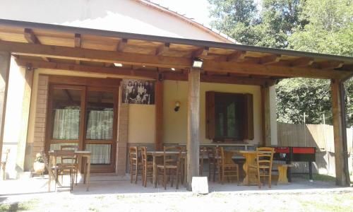 a patio with tables and chairs in front of a house at Agriturismo Rio Ricco in Busana