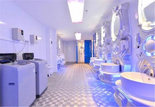 a bathroom with sinks and toilets in a room at Zhuhai Dreamers Capsule Hotel in Zhuhai
