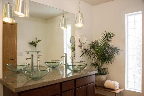 a bathroom with three bowl sinks on a counter at River Spring Lodge in Darien