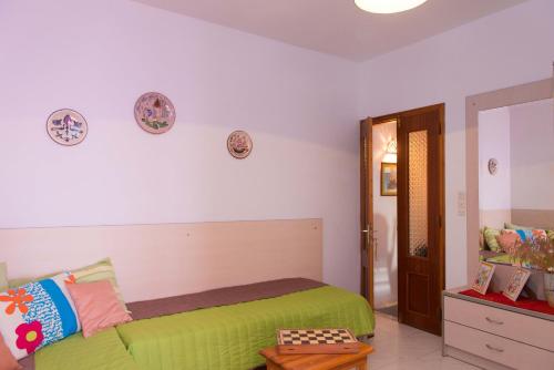 a bedroom with a bed with green sheets at Kyprianos house in Platis Yialos Sifnos