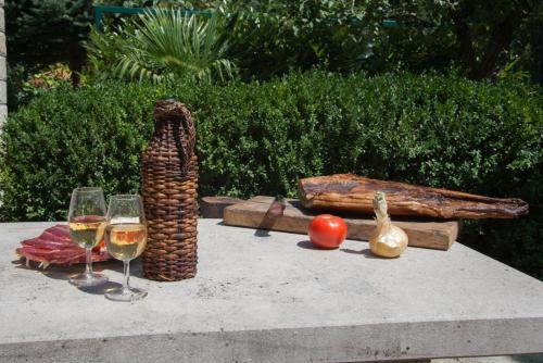 a table with two glasses of wine and some vegetables at Apartment Bibo in Grubine