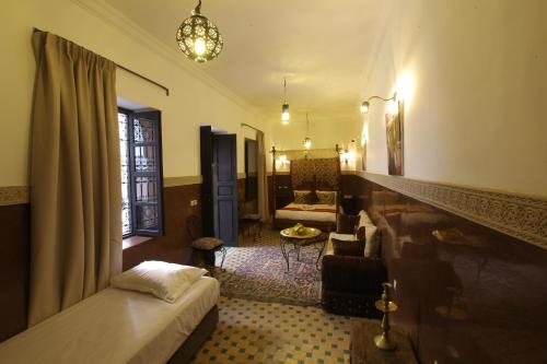 a bedroom with a bed and a living room at Riad Ciel d'Orient in Marrakech