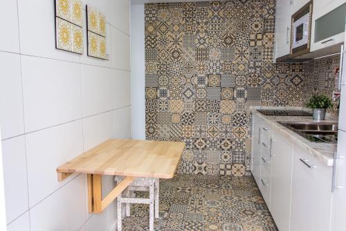 セジンブラにあるFilipe Village - Casa da Índiaのタイル張りの壁、木製テーブル付きのキッチン