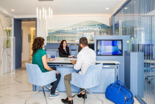 a group of people sitting at a counter in a office at Villa Gervasio in Bacoli