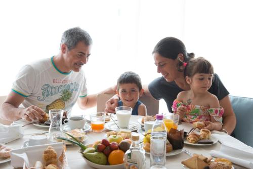 a family sitting at a table with plates of food at Hotel Riva del Sole in Marina di Campo