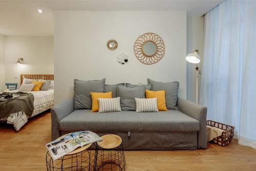 uma sala de estar com um sofá cinzento com almofadas amarelas em MYA home General Vives em Las Palmas de Gran Canárias
