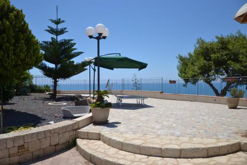 d'une terrasse avec une table et un parasol vert. dans l'établissement LOFT NICOLIZIA - Area Esterna Esclusiva con Vista Mare, à Licata