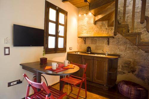 a kitchen with a table and chairs and a sink at Mystic Hotel - Adults only in Rhodes Town